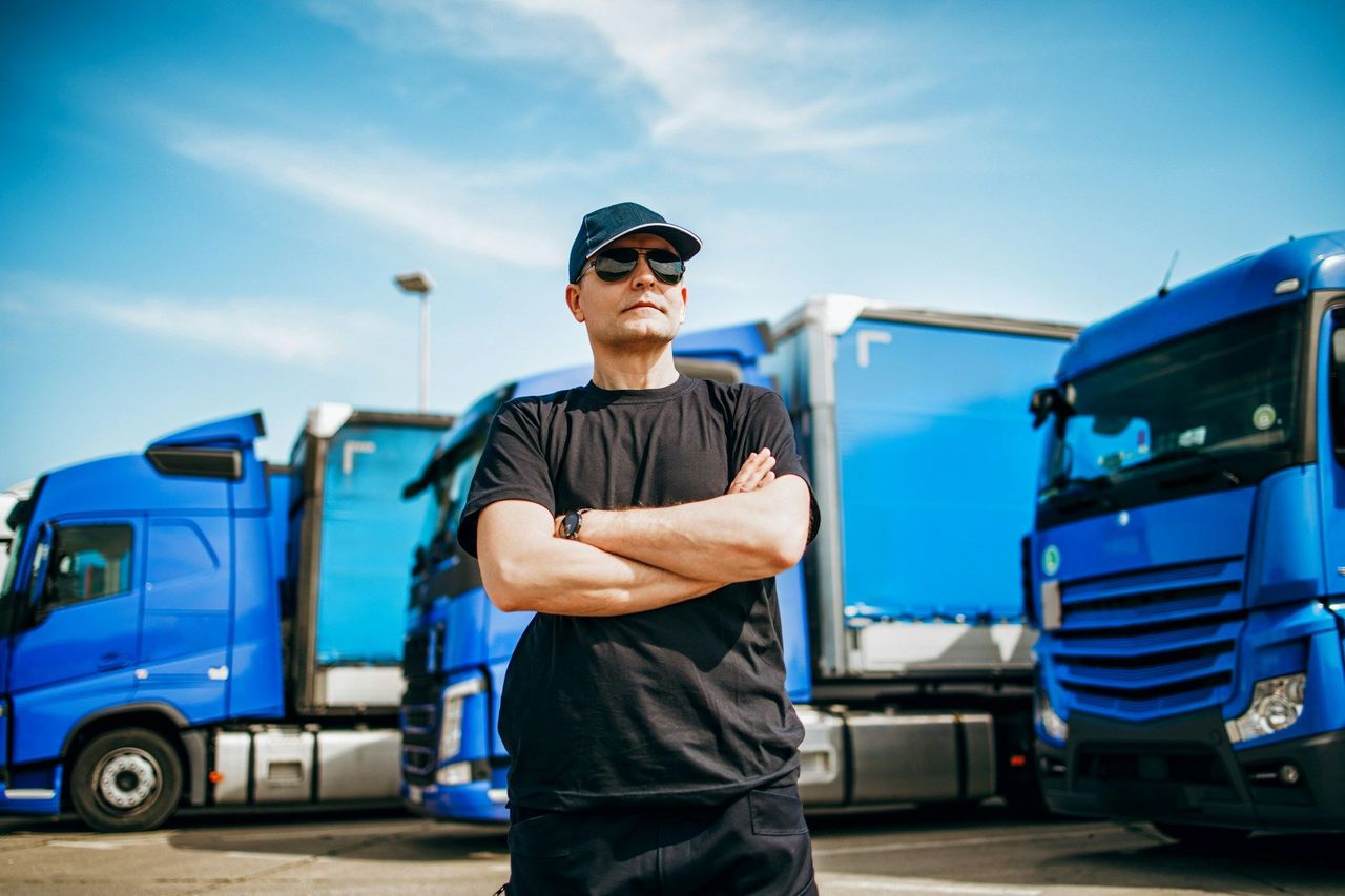 Independent owner-operator trucker in front of his trucks