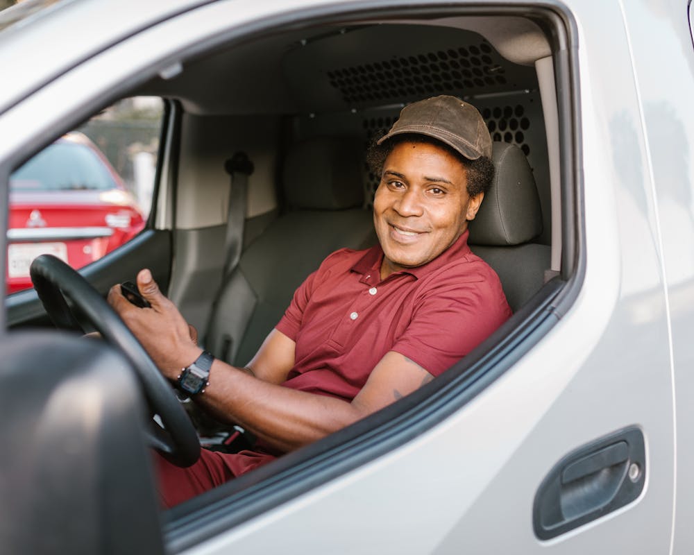 Smiling commercial driver in the cab of a van