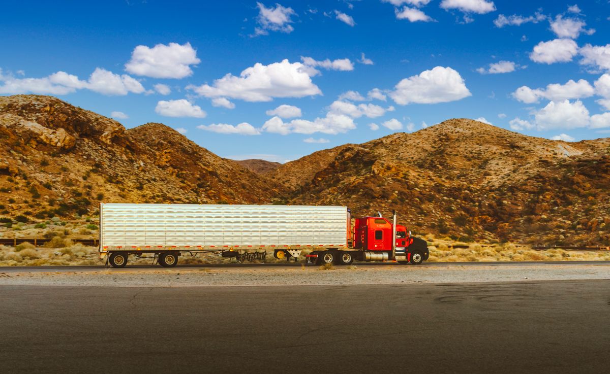 Semi-truck and trailer on a desert mountain highway