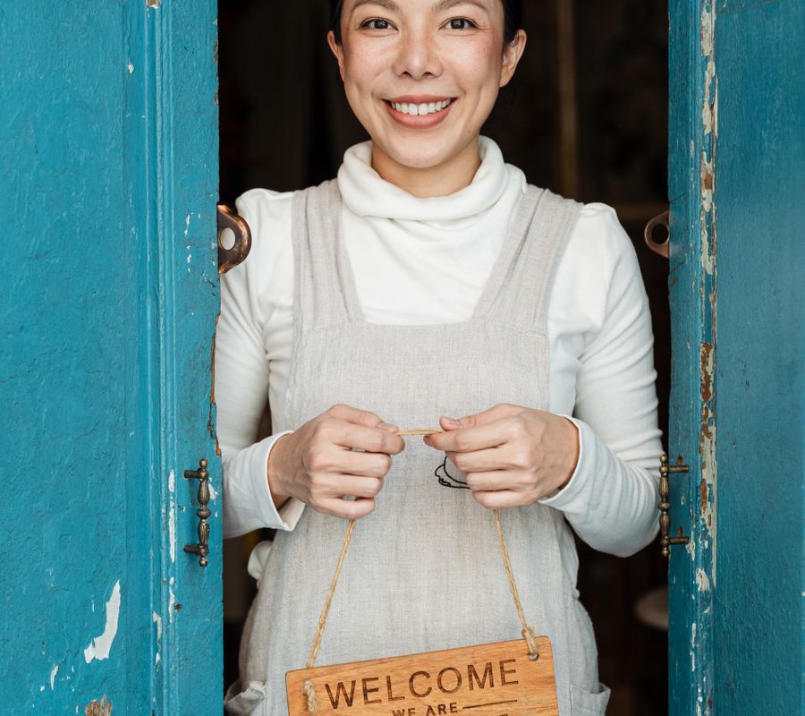 Smiling small business owner with an open sign