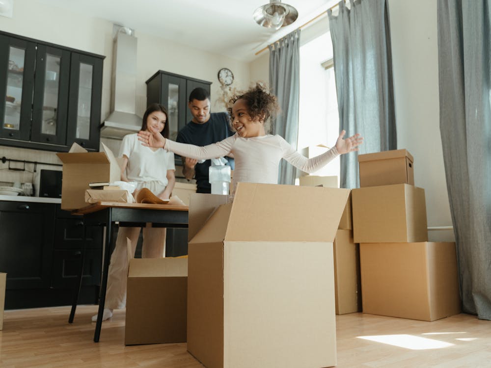 Happy family unpacking moving boxes in a bright new home