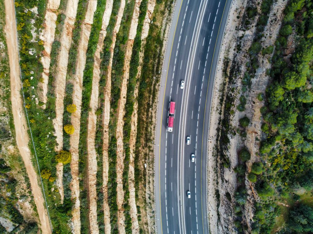 Aerial view of a highway winding through green hills
