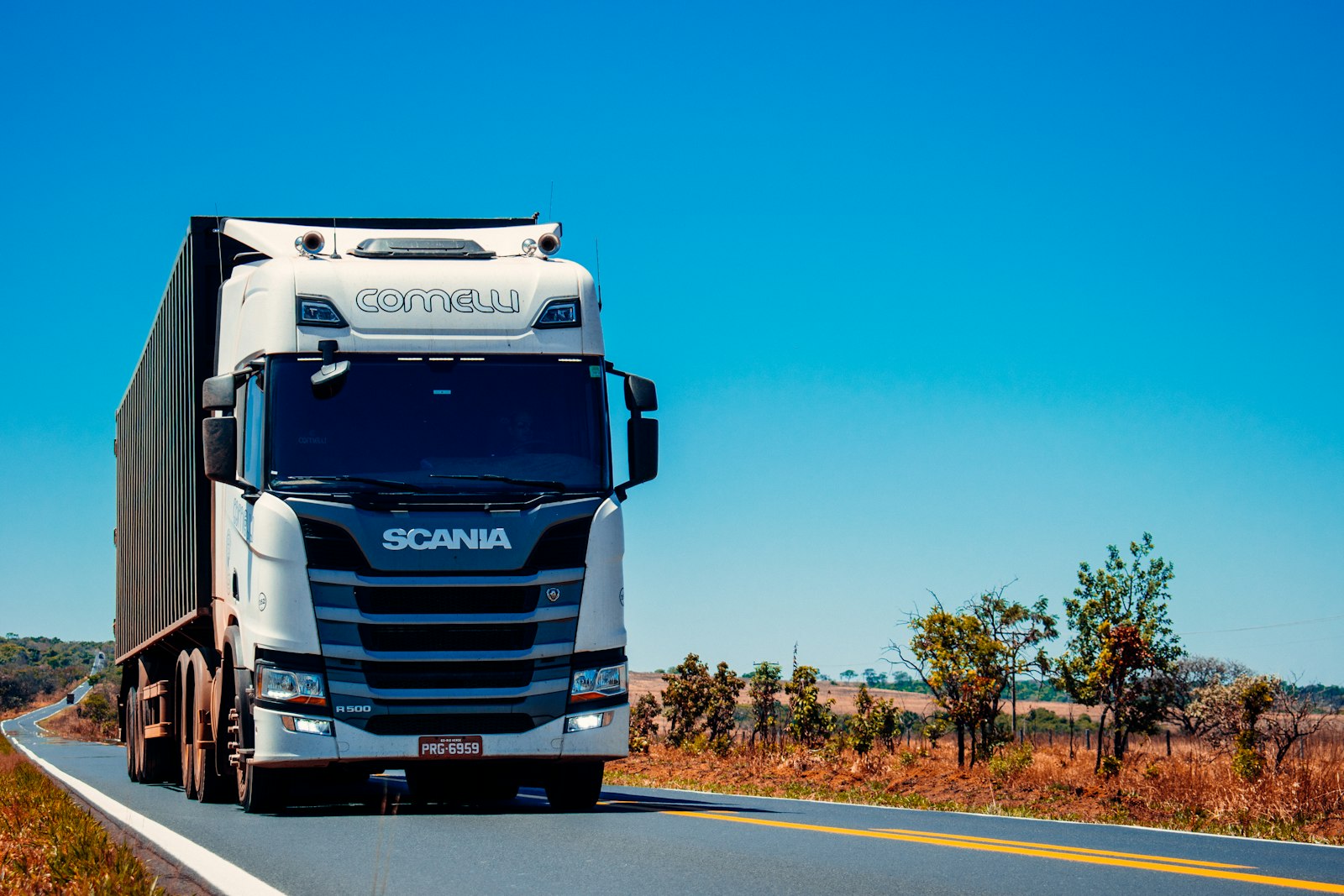 Commercial trucks on a tree-lined highway