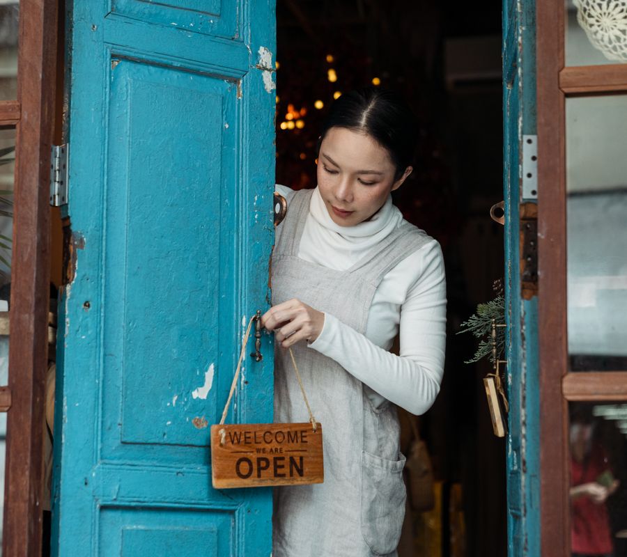 Small business owner hanging an open sign